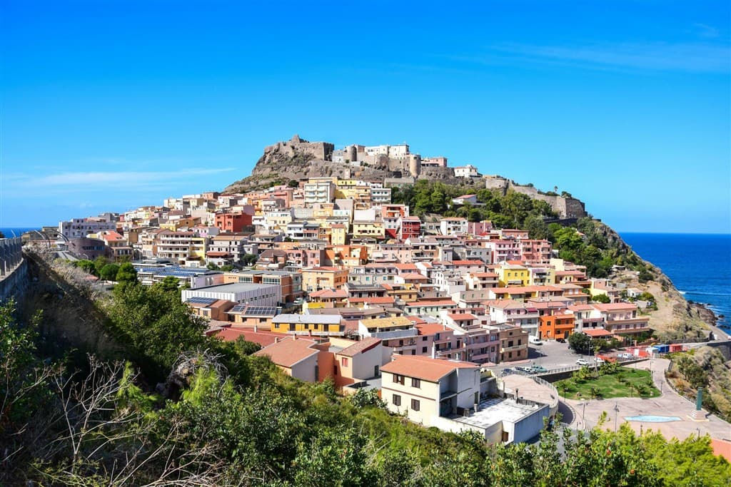 Domy na kopci v Castelsardo a more v pozadí na Sardínii.