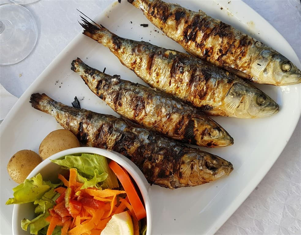 Grilované ryby na tanieri a zelenina.