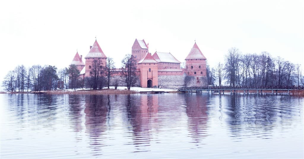 Zasnežený hrad Trakai na jazere v Litve.