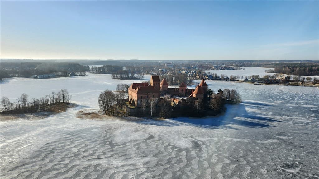 Zmrznuté jazero a hrad Trakai na malom ostrove v Litve.