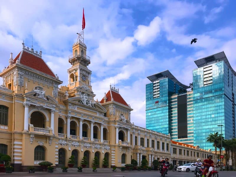 Koloniálna budova a moderný hotel v Ho Či Minovom mesto vo Vietname.