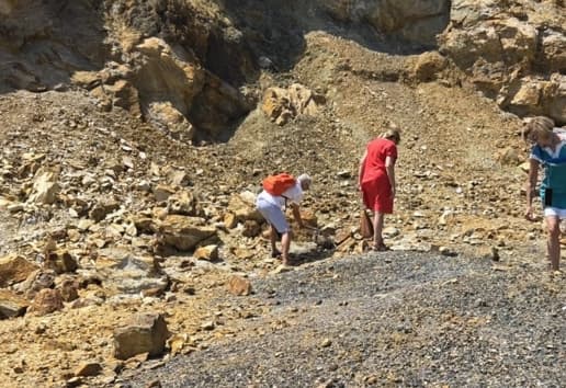 Traja ľudia zbierajú minerály v lome na Elbe.