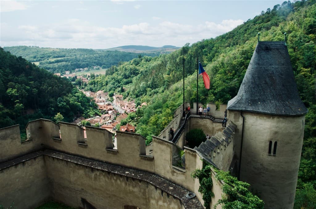 Hradná veža Karlštejnu a zelené kopce.