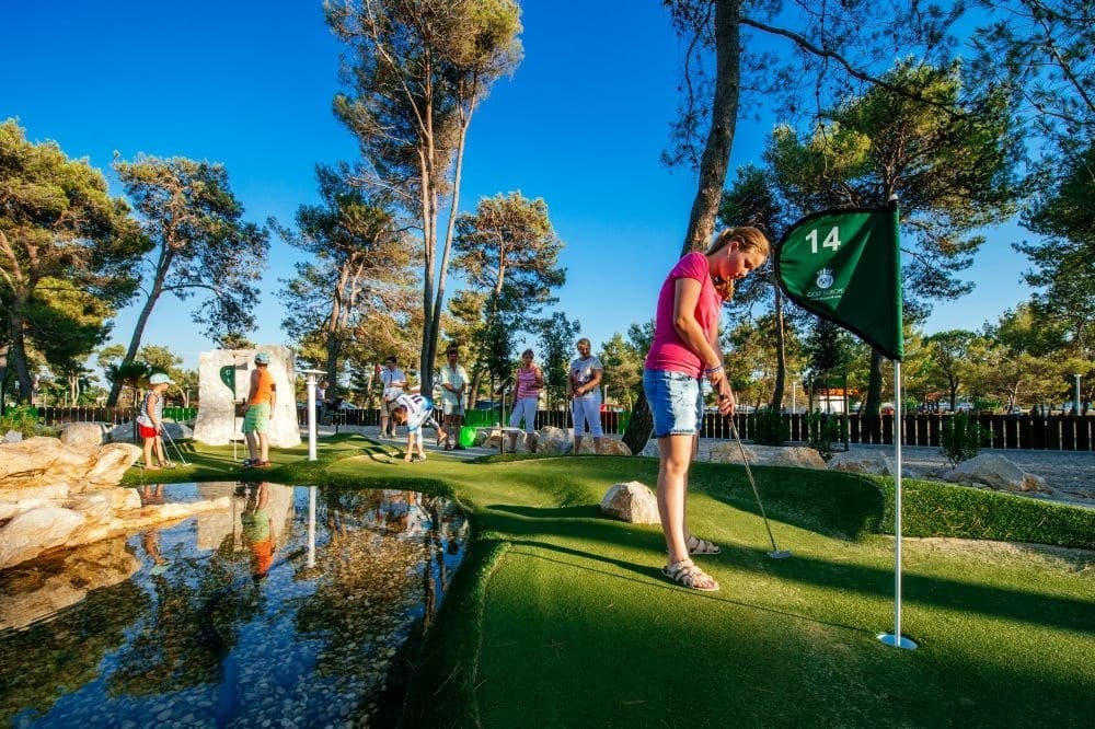 Dievča na golfe usilujúce sa trafiť jamku