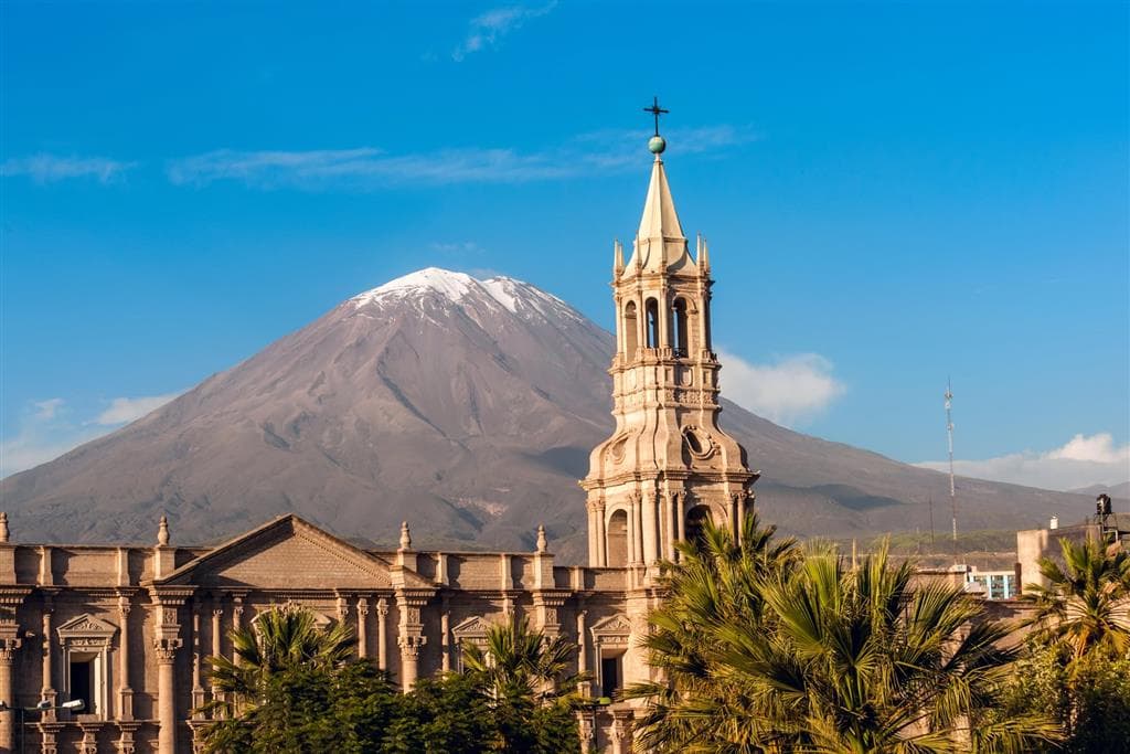 Sopka El Misti na pozadí mesta Arequipa, v popredí vežička katedrály z bieleho vulkanického kameňa sillar