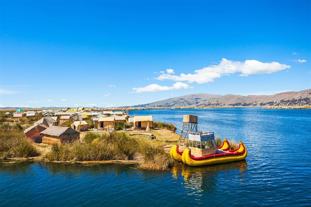 Trstinové plávajúce ostrovy Uros na jazere Titicaca, Peru, s tradičnými domami a loďkami