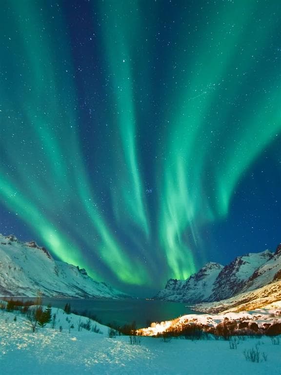 Aurora borealis - polárna žiara, sa rozlieva nad prístavným mestečkom Tromso v Nórsku